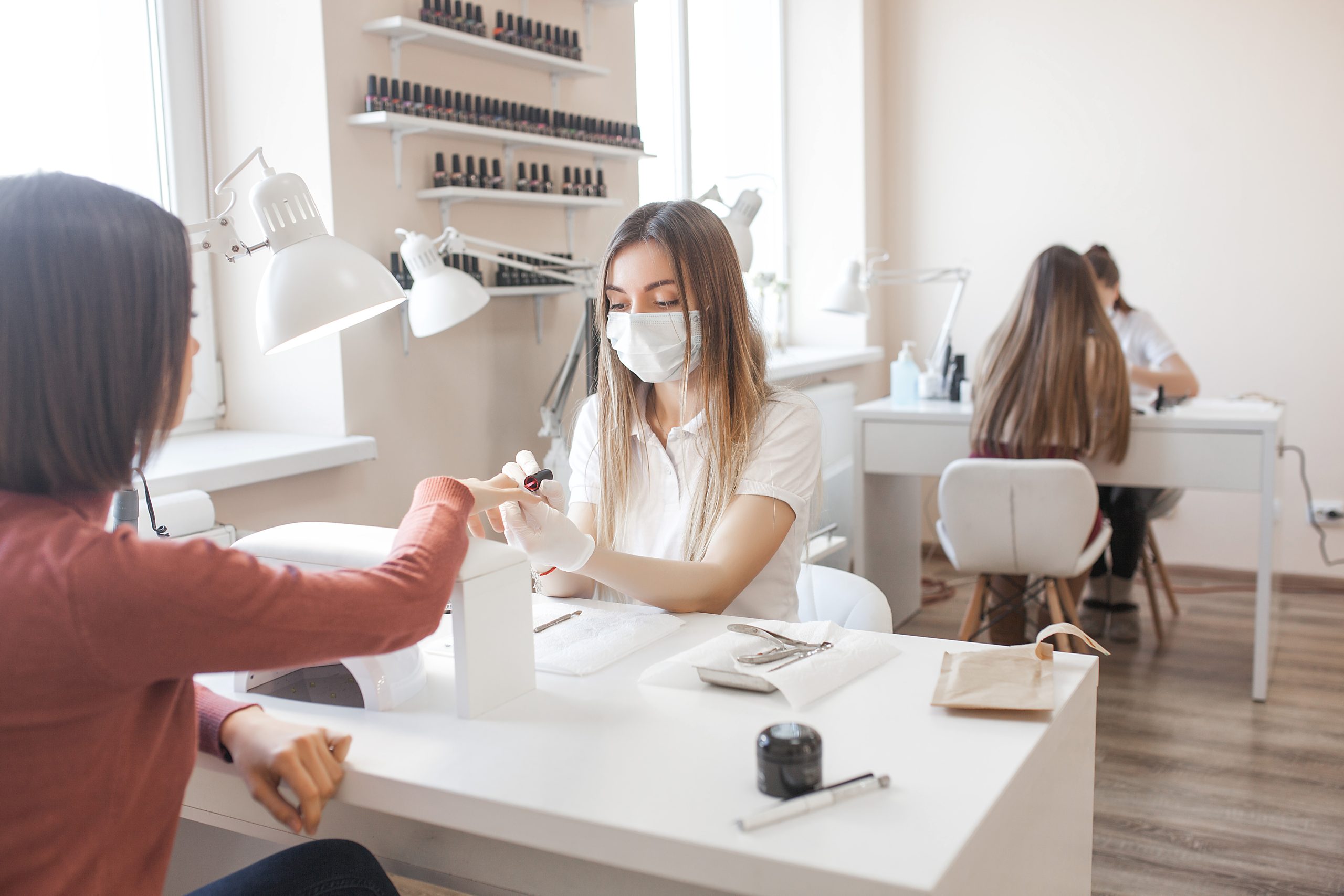 Manicurist servicing client nails care procedure