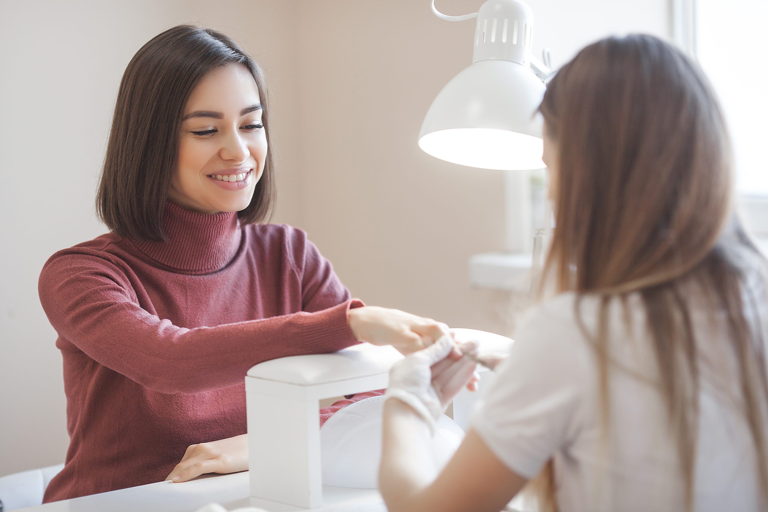 Manicurist making manicure in salon